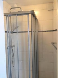 La salle de bains est pourvue d'une douche avec une porte en verre. dans l'établissement Carli's Bed-No-Breakfast, à Friedrichshafen