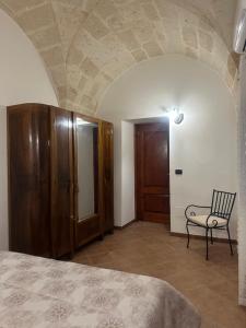 1 dormitorio con 1 cama y 1 silla en una habitación en Casa Vacanza - L’ Antica Torre, en Maruggio