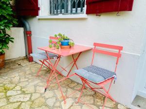 two red chairs and a pink table and chair at Sweet Home - 55m2 appt, garden, swimming pool, parking in Toulouse