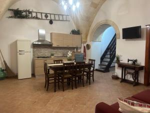 cocina y comedor con mesa y sillas en Casa Vacanza - L’ Antica Torre, en Maruggio