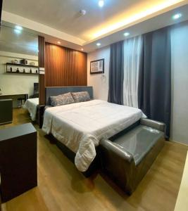 a bedroom with a large bed and a desk at At the Heart of Davao w/ Wifi, Netflix & Disney+ in Davao City