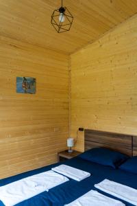 a bedroom with a bed and a wooden wall at Gorai in Kazbegi