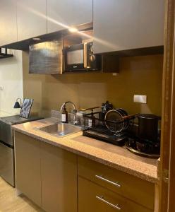 a kitchen with a sink and a stove at At the Heart of Davao w/ Wifi, Netflix & Disney+ in Davao City