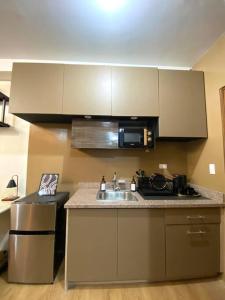 a kitchen with a sink and a microwave at At the Heart of Davao w/ Wifi, Netflix & Disney+ in Davao City