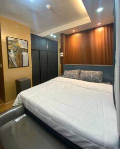 um quarto com uma grande cama branca em At the Heart of Davao w/ Wifi, Netflix & Disney+ em Dávao