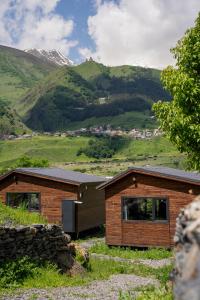 a house in a field with mountains in the background at Gorai in Kazbegi