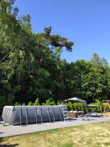 a group of tables and umbrellas in a park at Pokoje Gościnne Ontario Mieroszyno in Jastrzębia Góra