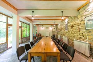 une salle de conférence avec une table et des chaises en bois dans l'établissement Eco Hotel Imenieto, à Emen