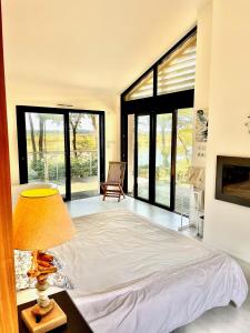 una camera con letto, lampada e finestre di Maison en bord de rivière de mer a Le Fenouiller
