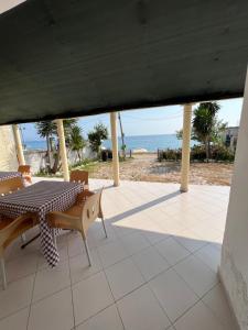 eine Terrasse mit einem Tisch, Stühlen und Meerblick in der Unterkunft Tony Home in Borsh