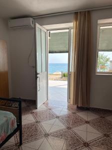 Dormitorio con puerta con vistas al océano en Tony Home en Borsh