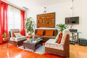 a living room with a couch and chairs and a tv at El Castillo de Azucar in Cali