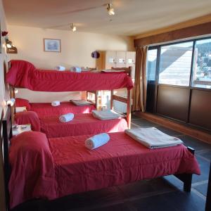 three bunk beds in a room with a window at Hospedaje Penthouse 1004 in San Carlos de Bariloche