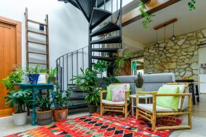una sala de estar con una escalera, sillas y plantas en La Siesta del Naranjo, en Monesterio