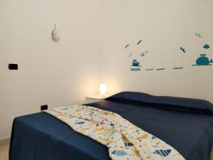 um quarto com uma cama com um edredão azul em Scala di Furno -Flora em Porto Cesareo