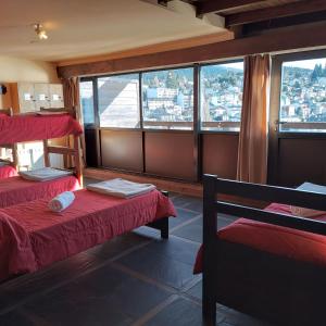 a room with two beds and a large window at Hospedaje Penthouse 1004 in San Carlos de Bariloche