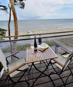 a wooden table with a bottle of wine sitting on a balcony at Apartment "OCEANVIEW" in Lubmin