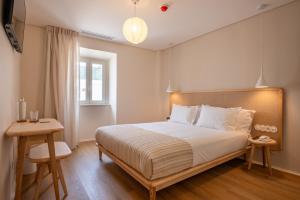 a bedroom with a large bed and a window at Praia FLH Hotels Ericeira in Ericeira