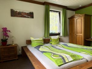 - une chambre avec un lit aux murs verts et une fenêtre dans l'établissement Pension Bennelliebschänke, à Seiffen