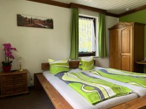 Schlafzimmer mit einem Bett mit grünen Wänden und einem Fenster in der Unterkunft Pension Bennelliebschänke in Seiffen