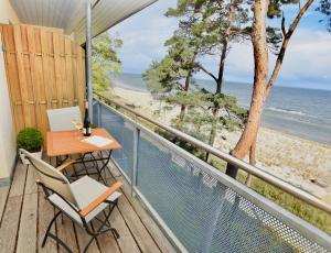a balcony with a table and chairs and the beach at Apartment "OCEANVIEW" in Lubmin