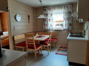 a kitchen with a table and chairs and a sink at Ferienwohnungen Pollhammer in Sankt Gallenkirch