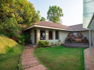 a house with a lawn in front of it at Urmilaa Green County Resort 35 KM From Kolhapur in Kolhapur