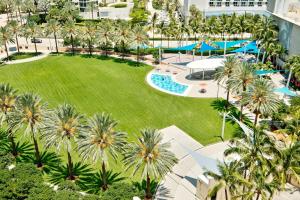 einen Luftblick auf ein Resort mit Palmen und einem Pool in der Unterkunft COLLINS AVE SUNNY VACATION in Sunny Isles Beach