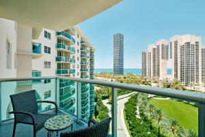 a balcony with chairs and a view of the ocean at COLLINS AVE SUNNY VACATION in Sunny Isles Beach