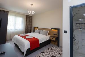 Moonlight Suite Hotel في طرابزون: غرفة نوم بسرير كبير مع بطانية حمراء