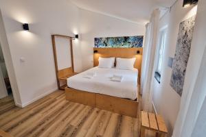 een slaapkamer met een groot bed en een spiegel bij Volcanic Boutique Hostel in Angra do Heroísmo