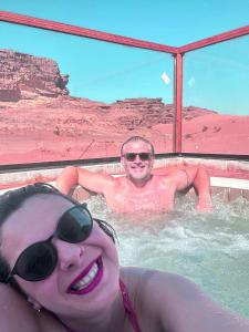 a man and a woman in a hot tub at orbit camp 2 in Wadi Rum