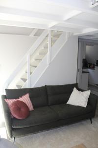 a couch in a living room with a staircase at L'Écureuil - Terrasses de Malmedy in Malmedy