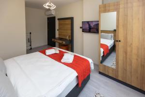 1 dormitorio con 2 camas y espejo en Moonlight Suite Hotel, en Trabzon