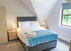a bedroom with a bed with a blue blanket on it at Old Court Holiday Homes 3 Bed - Sleeps 6 in Terryglass