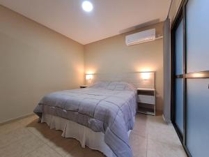 a bedroom with a bed and two lights on the wall at Departamentos en Tupungato in Tupungato