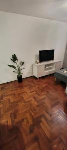 a living room with a wooden floor and a flat screen tv at Beautiful Apt on the Peatonal in Mendoza