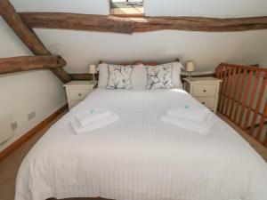 um quarto com uma cama branca com duas toalhas em Bramble Corner Cottage em Saltburn-by-the-Sea