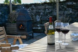 - une bouteille de vin et 2 verres à vin sur une table dans l'établissement Achalic Farm House, à Lerags