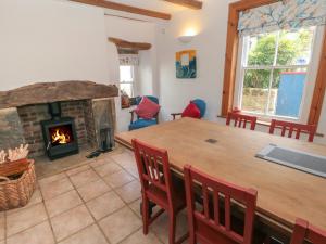 uma sala de estar com uma mesa e uma lareira em Bramble Corner Cottage em Saltburn-by-the-Sea