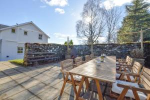 a wooden table and chairs on a patio at Achalic Farm House in Lerags