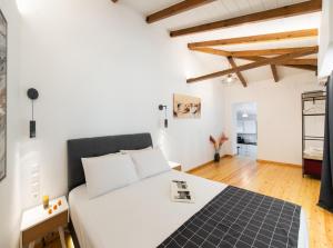 a bedroom with a white bed and a wooden floor at Villa Nika in Palaiokhóri