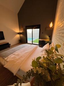 1 dormitorio con 1 cama grande y ventana en شاليه كوتج, en Buraidah