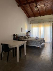 una camera con letto, tavolo e letto Sidx Sidx Sidx di Complejo San Cristobal a Santa Clara del Mar