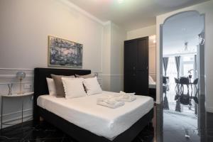 a bedroom with a bed with white sheets and a mirror at Le Parisien de COUP DE COEUR APPARTEMENTS in Valencia