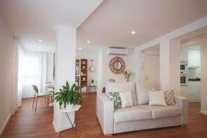 a living room with a white couch and a table at Amage Suite in Castellón de la Plana