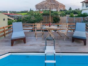 patio ze stołem i krzesłami przy basenie w obiekcie Alcyone Two Bedroom Country House with private pool w mieście Kavrokhórion