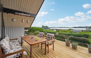 een houten terras met een houten tafel en stoelen bij Amazing Home In Kirke Sby With House A Panoramic View in Kirke Såby