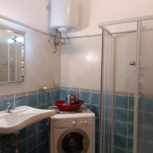 een badkamer met een wasmachine en een wastafel bij Domu abi manna in Tertenìa