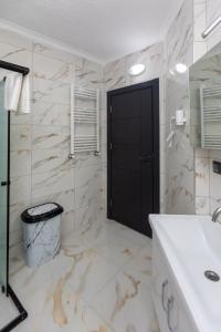 ein Badezimmer mit Waschbecken und schwarzer Tür in der Unterkunft Moonlight Suite in Trabzon + 90 Fotos